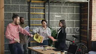 多民族<strong>创业</strong>的同事在现代办公室里跳舞，扔纸文件，庆祝